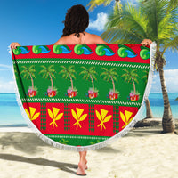 Round Christmas beach blanket in green and red with palm accents, pine symbols, and fringe