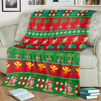 Green Christmas blanket folded on a couch with red, yellow bow motifs, and Santa faces