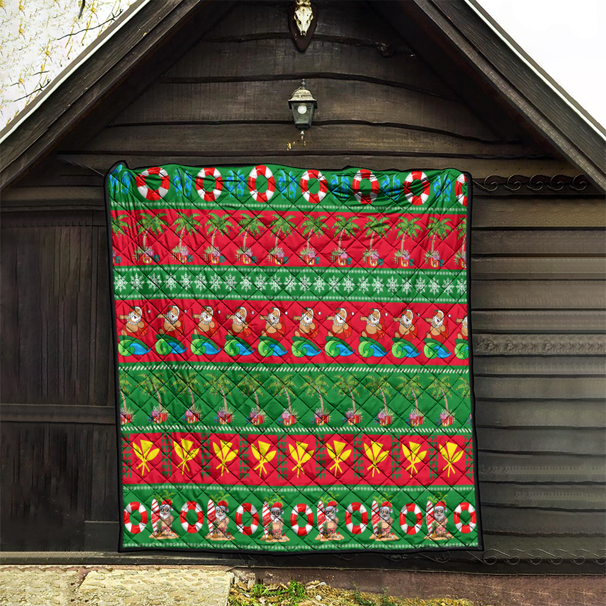 Hawaiian Christmas quilt hanging on porch, green and red stripes with palm trees, waves, and Santa