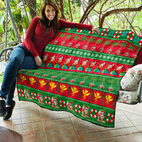 Hawaiian Christmas quilt held up, green and red holiday print with palm trees, waves, and Santa