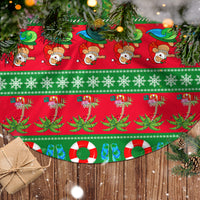 Green and red Christmas tree skirt fabric with repeating tropical holiday icons