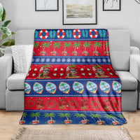 Christmas blanket draped over sofa, blue-and-red festive stripes with palm trees
