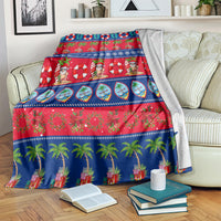 Christmas blanket laid on couch, blue-red festive stripes with palm trees and flowers