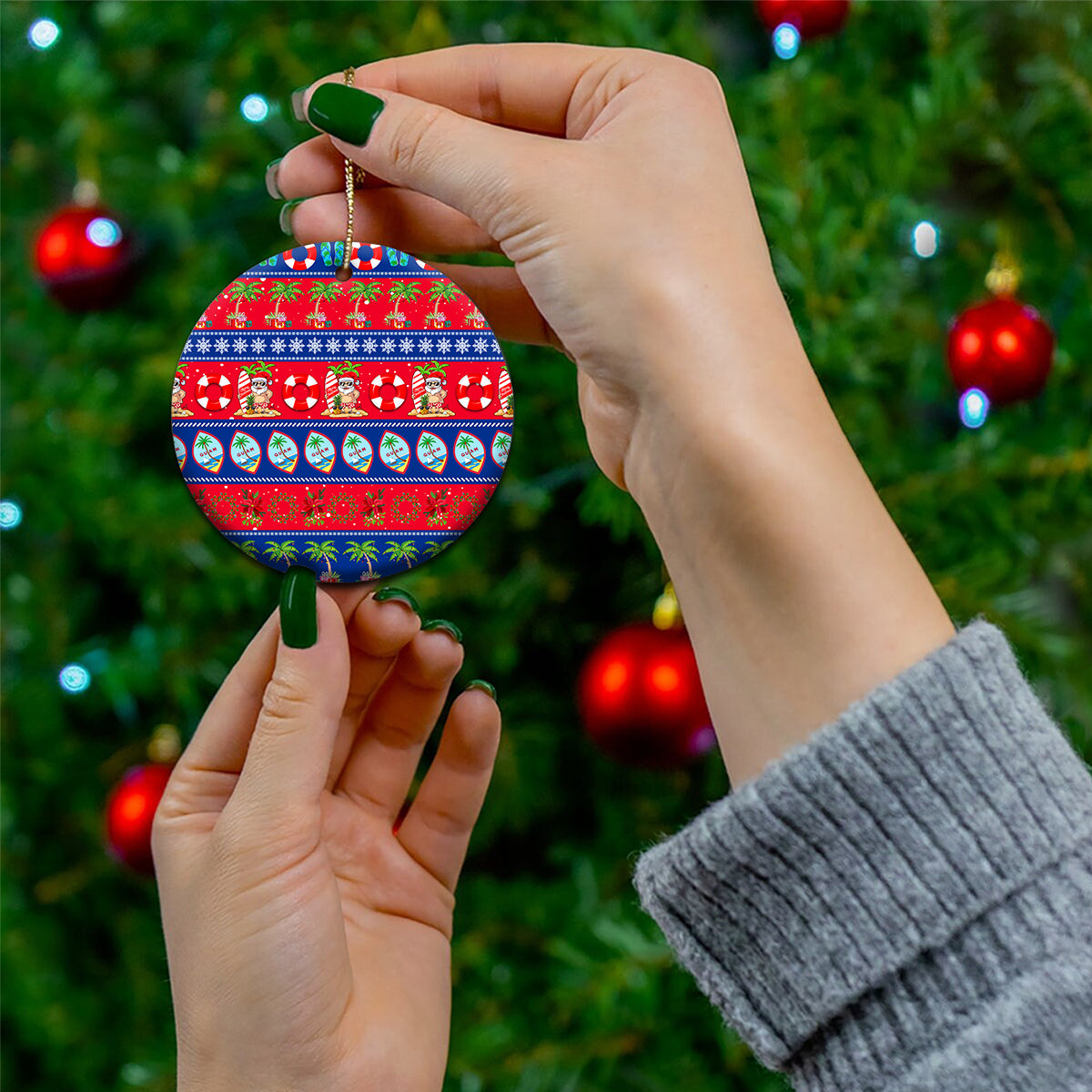 Round ceramic Christmas ornament held in hand, red and blue holiday tropical pattern