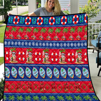 Christmas quilt with blue and red border, Santa figures, palm trees, and festive icons