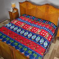 Christmas quilt laid on bed with red base, blue border, Santa, and palm tree print