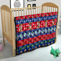 Christmas quilt on baby bed with red and blue print, Santa characters and palm trees