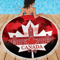 Red round beach blanket with Canada Day lettering, white maple leaf graphic, fringed edge
