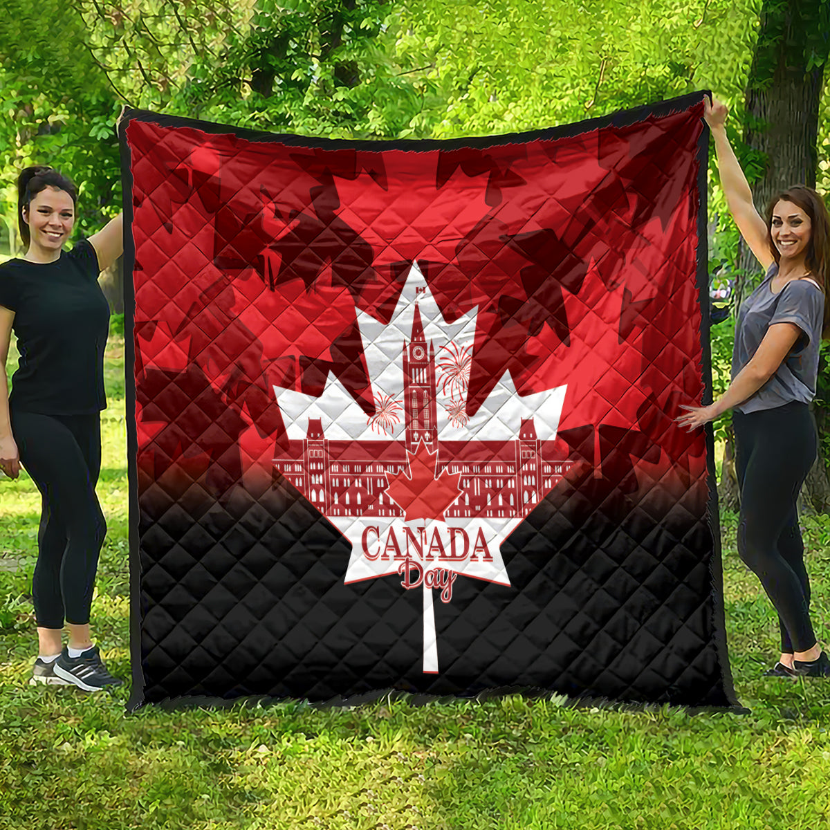 Quilt blanket showing white maple-leaf city and Canada Day text over red/black panels.