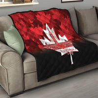 Quilt blanket on sofa, red top and black bottom with white maple-leaf city graphic.
