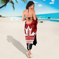 Red and black Canada-themed sarong with maple leaf and building graphic, draped on model