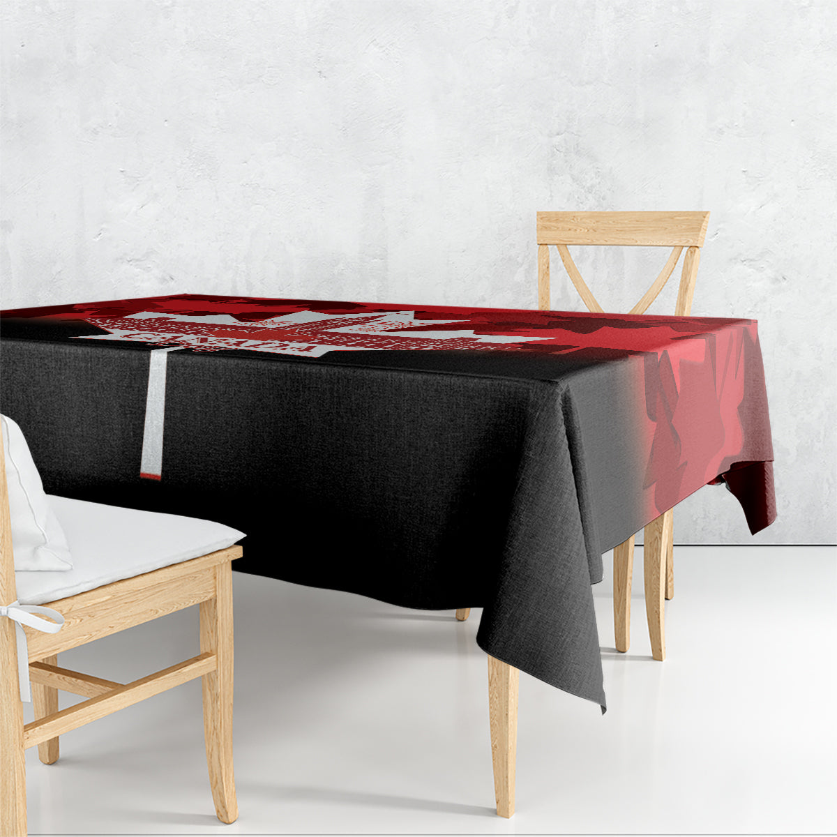 Rectangular tablecloth draped over square table, red maple leaf print on black base