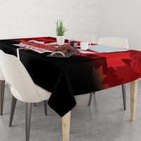 Red and black Canada Day tablecloth with maple leaf shapes on dining table