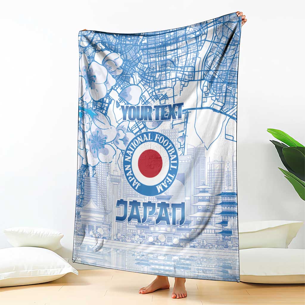 Blue Japan football blanket with large circular emblem and city street pattern, draped