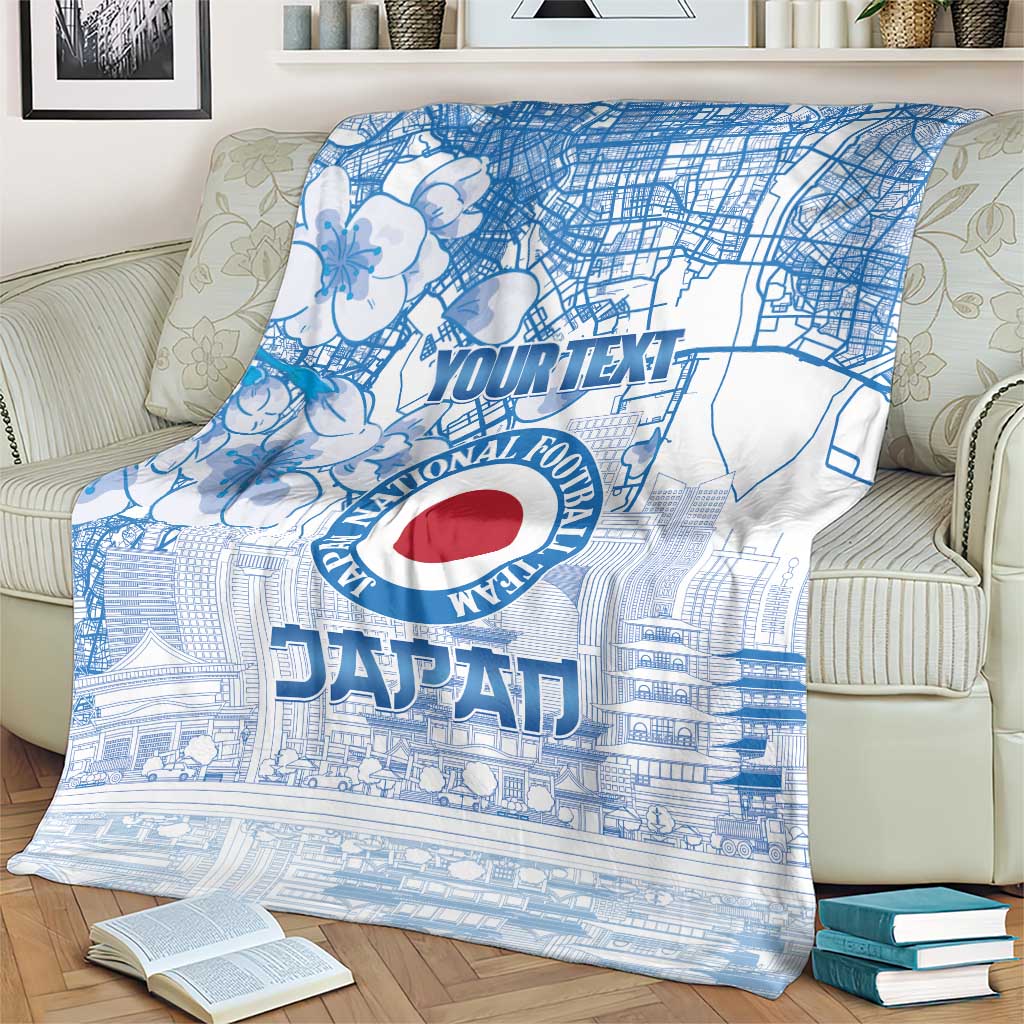 Blue Japan football blanket on a cream chair with city map art and red circular emblem