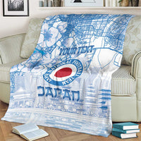 Blue Japan football blanket on a cream chair with city map art and red circular emblem