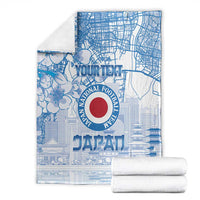 Folded blue Japan football blanket with city map design and red circular emblem