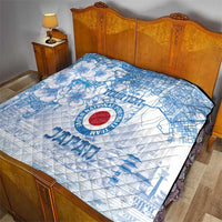 Blue and white quilt on a bed showing Japan football logo and city map with cherry blossoms