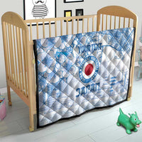 Blue and white quilt laid in a crib with Japan football logo and cherry blossom city design