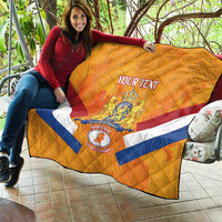 Orange Netherlands rugby quilt on couch, showing diagonal stripes and centered crest