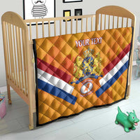Orange Netherlands rugby quilt on baby bed, with diamond stitching and central crest
