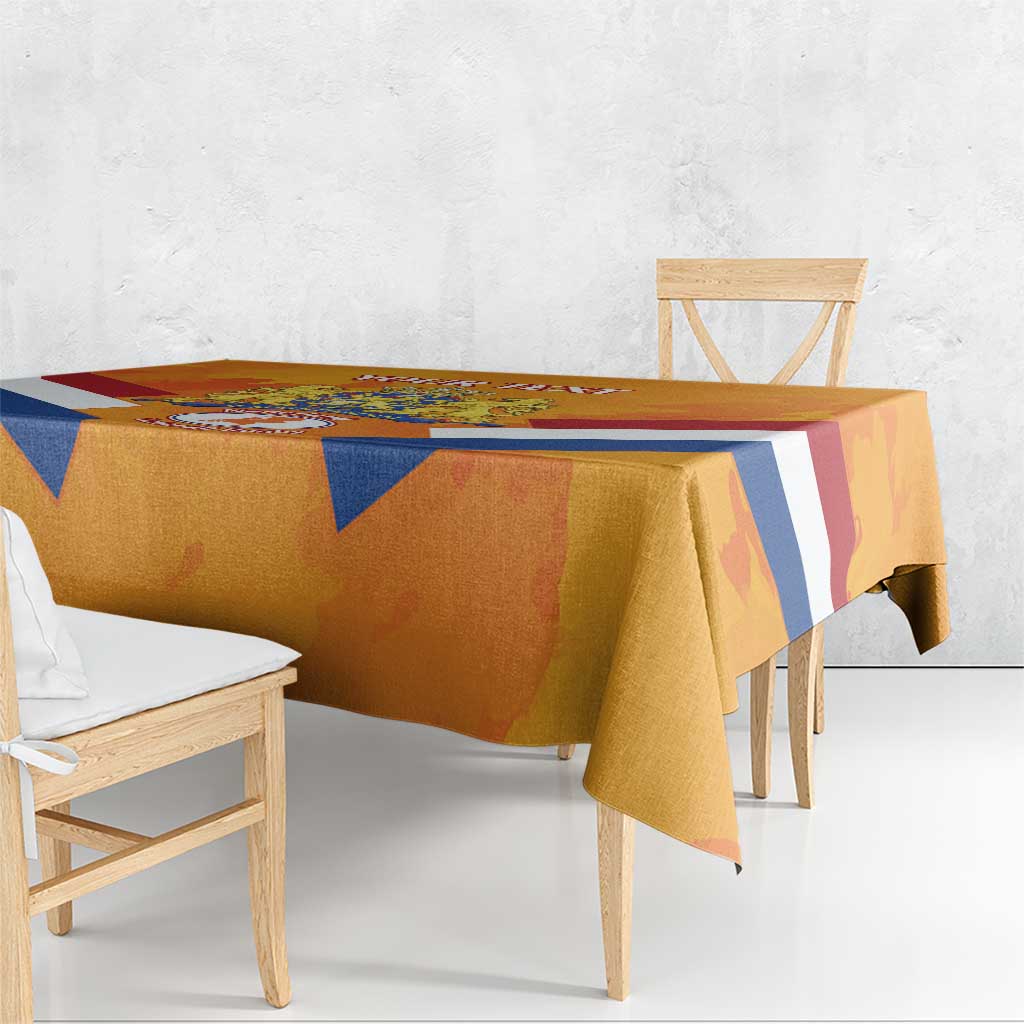 Orange tablecloth draped over dining table edge with blue diagonal stripes and red accents