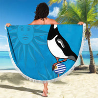 Blue circular beach blanket with white fringe, bird and sun face design held outdoors
