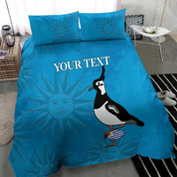 Blue duvet cover and pillowcases with "YOUR TEXT" and penguin holding striped bottle