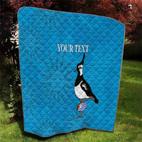 Blue quilt on grass featuring penguin graphic and 'Your text' text.