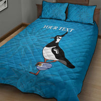 Blue quilt bed set with two pillows, penguin graphic and 'YOUR TEXT' on quilt.