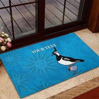 Blue rubber doormat with bird graphic, 'YOUR TEXT', and sunburst pattern