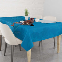 Blue rectangular tablecloth draped on a dining table with penguin and floral print