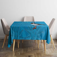 Blue tablecloth featuring penguin and tropical sunburst design on a dining table