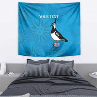 Blue tapestry with penguin, striped ball, and sunburst pattern