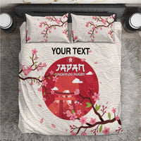 White duvet cover and two pillowcases with pink cherry blossoms and red rugby emblem circle