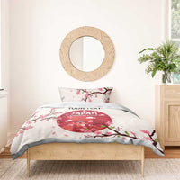 White duvet cover and two pillowcases with pink cherry blossom branches and red sports graphic
