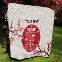 White quilt blanket on grass with red Japan Under-20 rugby emblem and cherry blossom flowers.