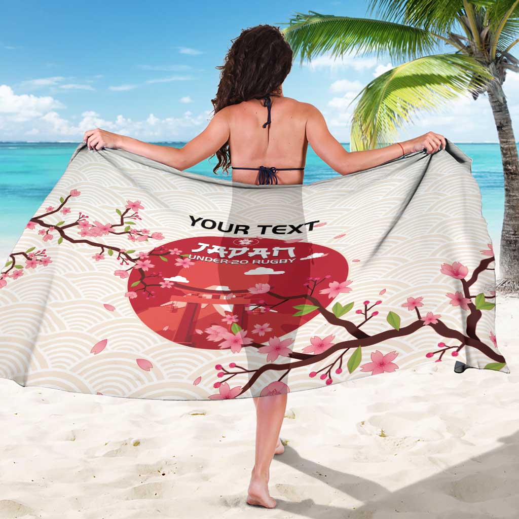 Back of white rugby sarong with wave pattern, cherry blossoms, and red emblem
