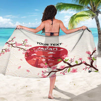 Back of white rugby sarong with wave pattern, cherry blossoms, and red emblem