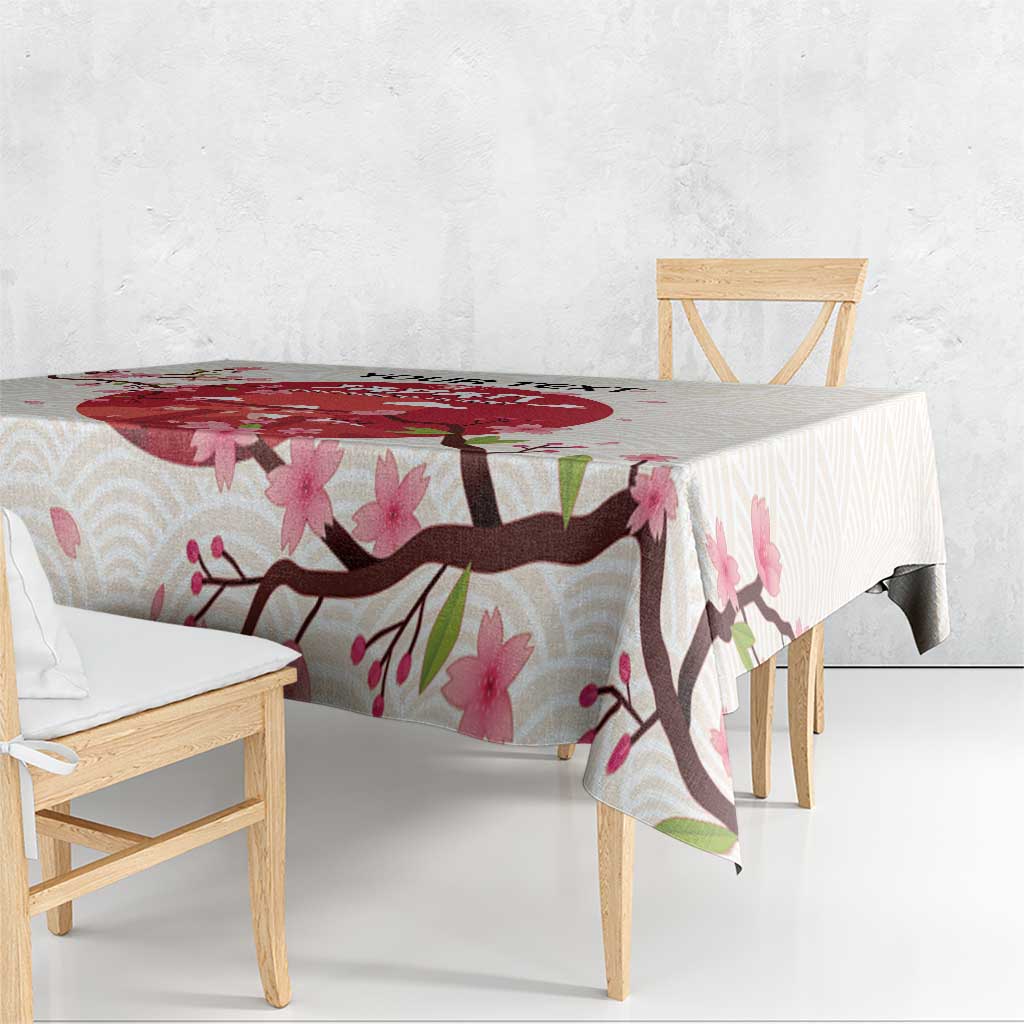 White tablecloth with pink blossoms and dark branch detail along the table edge