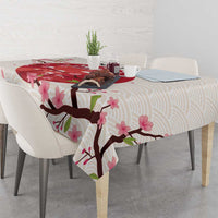 White tablecloth with pink cherry blossoms and branch design on a dining table