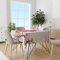 White tablecloth with pink cherry blossoms and branch pattern on a dining set