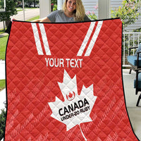 Red quilt with white maple leaf, striped accents, and “CANADA UNDER-20 RUBY” text