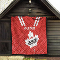 Red quilt hanging outside with white maple leaf and “CANADA UNDER-20 RUBY” text