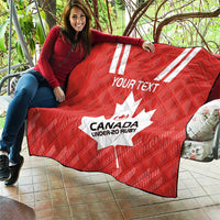Red rugby quilt laid outdoors with white maple leaf and “CANADA UNDER-20 RUBY” print