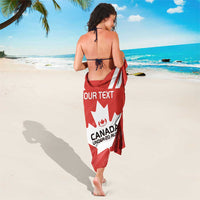 Red Canada rugby sarong worn as beach wrap, back view with white maple leaf logo