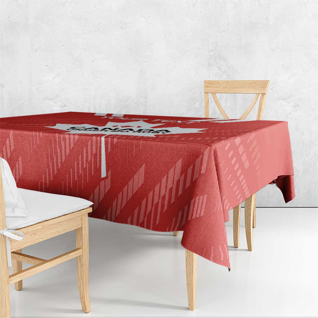 Red tablecloth draped over square dining table with matching chairs and maple leaf graphic.