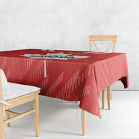 Red tablecloth draped over square dining table with matching chairs and maple leaf graphic.