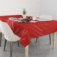 Red tablecloth on dining table with chairs, featuring bold white Canada-style maple leaf design.