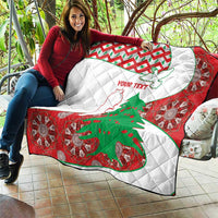 Person holding a red, white, and green Lebanon quilt showing map and cedar tree graphic
